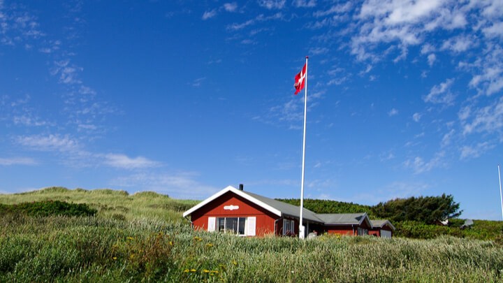 Red sommerhouse in green landscape